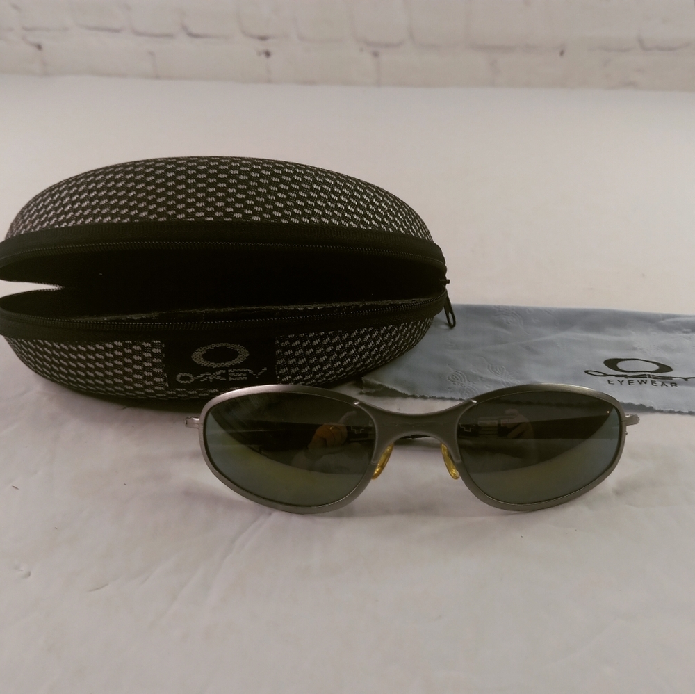 Oakley Silver Frame Sunglasses with Dark Green Lenses
